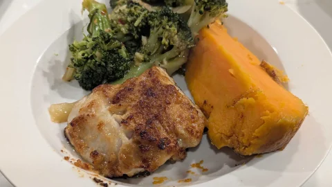 A plate of golden glazed fish, green broccoli and orange sweet potato.